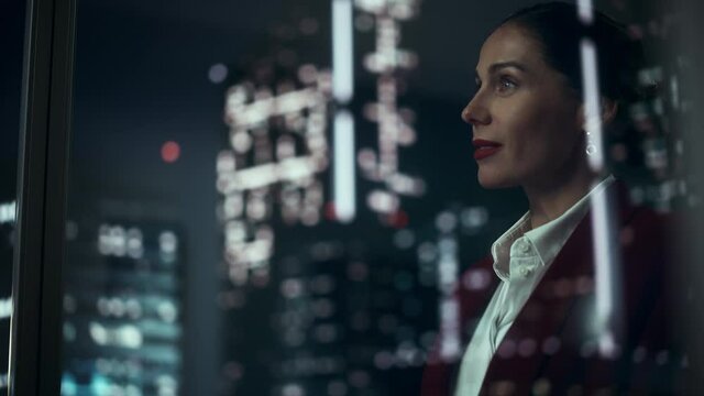 Successful Businesswoman in Stylish Suit Working on Top Floor Office Overlooking Night City. High Achievement Female CEO of Humanitarian Investment Fund, Human Face of Sustainable Corporate Governance
