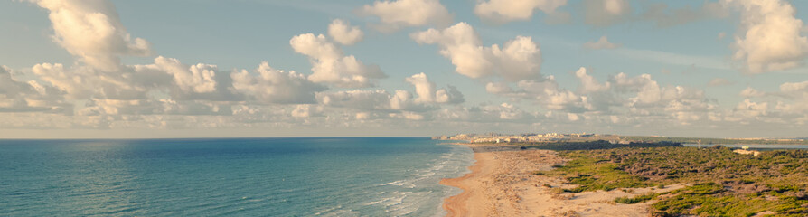Aerial drone point of view sandy beach of La Mata and Mediterranean sea in the early morning. Costa Blanca, Spain. Summer holidays and travel concept