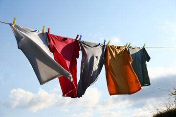 Clothes hanging on washing line against sky