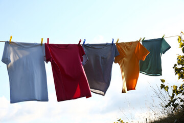 Clothes hanging on washing line against sky