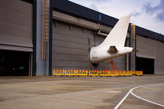 The empennage or tail of aircraft during maintenance in hangar at airport