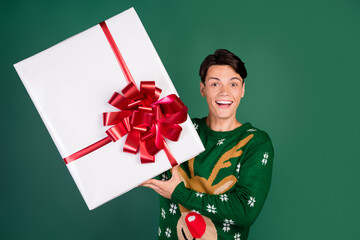 Photo of crazy funky guy hold big giftbox omg face wear deer ornament sweater isolated green color background