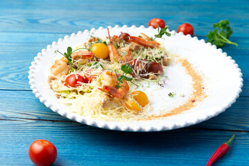 Shrimp salad in a plate. On a blue, wooden background.