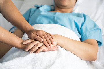Fototapeta na wymiar Close up doctor taking patients hand on the bed in hospiital.Nurse hand holding patient hand for empowerment.Care giver touching hand patient in clinic.Psychological support concept.