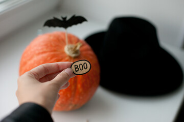 halloween pumpkin with black hat and little bats and boo decor