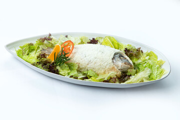 Dorado baked in salt in a plate. Isolated on white background.