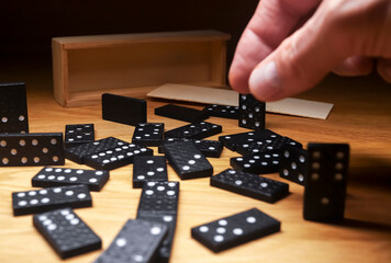 Domino game pieces scattered on wooden desk with wood box. - Powered by Adobe