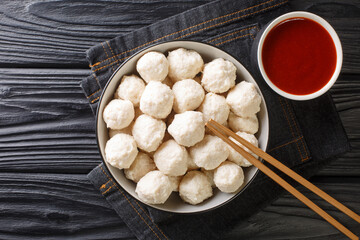 authentic Indonesian boiled chicken meatballs Bakso served with hot sauce close-up in a bowl on the table. horizontal top view from above