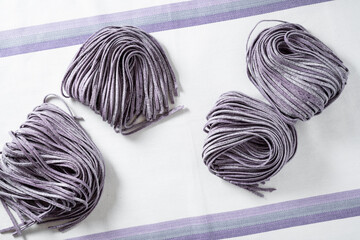 fresh raw homemade purple blueberry pasta on tablecloth