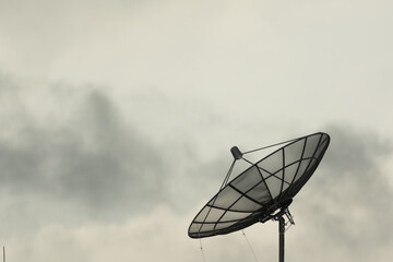 Satellite dish on building deck roof.Satellite receiver on sky and clouds background.