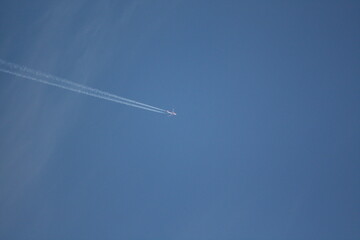 Flugzeug am blauen Himmel mit Kondensstreifen