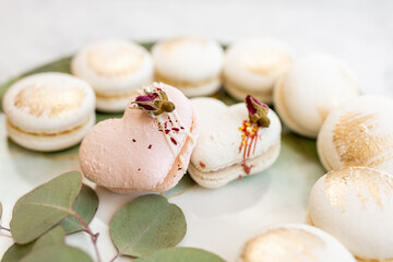 White macaroons are on a plate. Delicious light cookies on a plate on a light background. Bakery