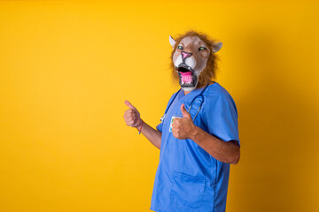 Doctor with lion mask making ok sign with hands. Yellow background.