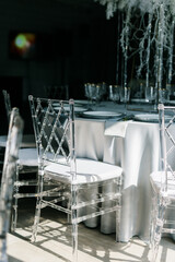 Transparent plastic Chiavori chairs for guests on the street close-up. Autumn wedding ceremony on the street on the green lawn.