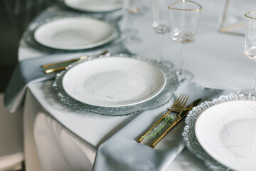 glass glasses and white plates. table setting in the interior of the restaurant. The decor of the...