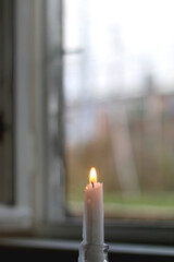 Lit candlestick in a glass candle holder. Selective focus.