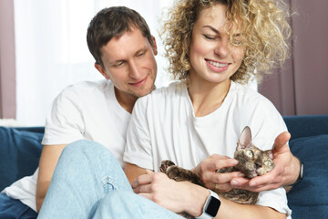 Young couple with their lovely cat relaxing at home