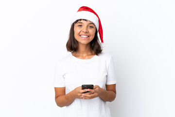 Young mixed race woman celebrating Christmas isolated on white background sending a message with the mobile