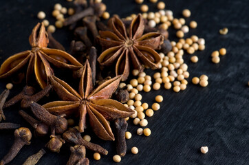 Fototapeta na wymiar Macro Image of Clove,Star Anise and Mustard Seeds on Black Background