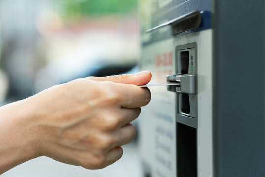 Female hand with a credit card and ticket vending machine