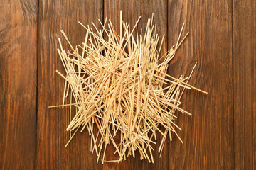 Dried hay on wooden background, top view