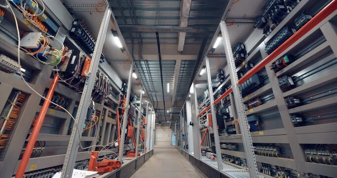 Industrial equipment control room corridor with many wires, electrical parts, automatic switches, breakers, residual current devices, fuses, terminals 