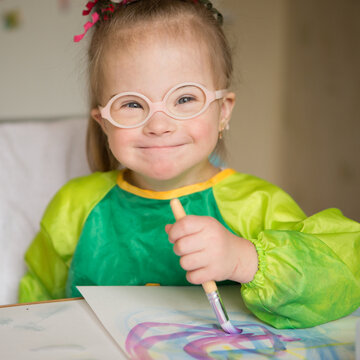 Girl with Down syndrome covered in paint when drawing