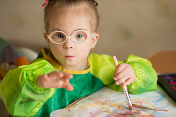 Girl with Down syndrome covered in paint when drawing