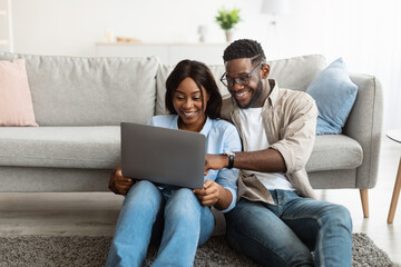 Portrait of African American couple using computer in living room