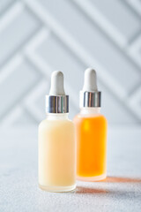 Glass bottles with face or body skin care products on a light background. Self-care, cosmetics, beauty practices, self-care concept.