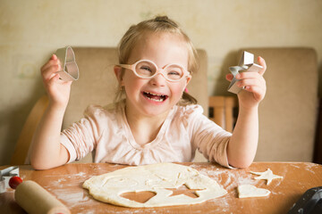 girl with down syndrome unrolls dough