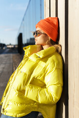 Stylish gor; wearing yellow puffer and orange knitted hat