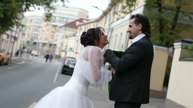 romantic just married couple on city street in wedding day, happy man and woman