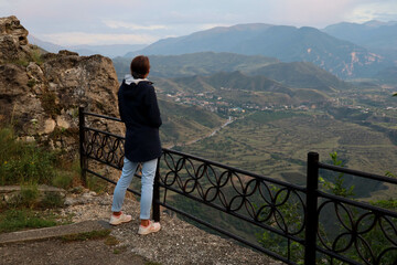 Fototapeta na wymiar young woman on the top of the mountain enjoy the scenic view in Gunib, Dagestan