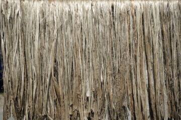 Closeup view of raw jute fiber. Rotten jute is being washed in water and dried in the sun. Brown jute fiber texture and details background. 