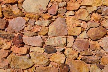 Mur en pierres rouges issues de roches ferreuses