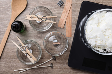 Flat lay composition with ingredients for homemade candles on wooden background