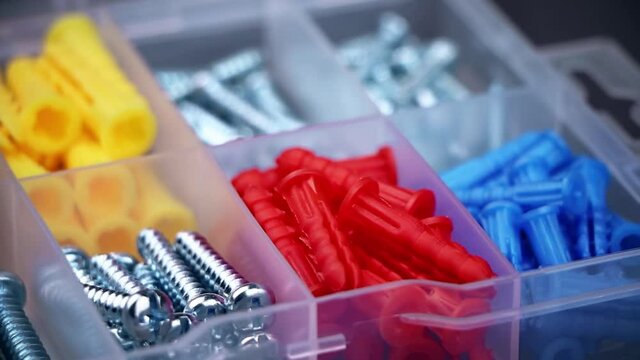 Set of colorful dowel, screw, fastener. A box with dowel, bolt and screw. Set of building tools.