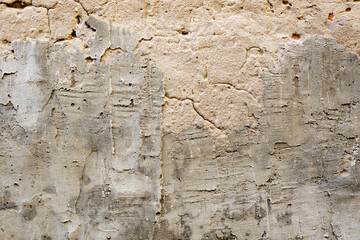 The texture of an old concrete wall. The texture of the brick and concrete wall. The texture of plaster and concrete, on top of brick.
