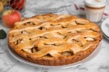Delicious traditional apple pie on white marble table, closeup