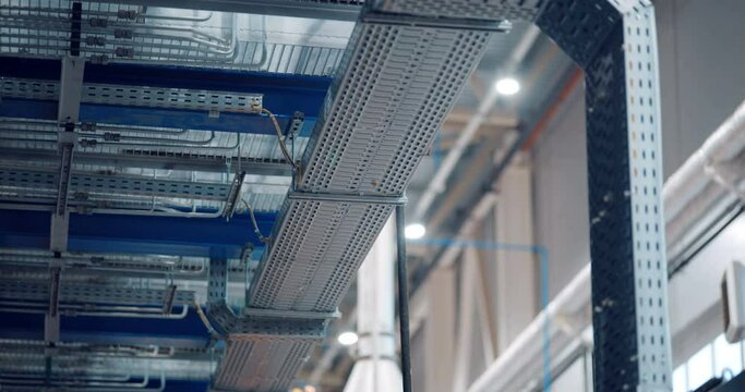 In a woodworking plant, an industrial line of equipment where rows of metal pipes that can withstand a lot of pressure do a specific job in the production 