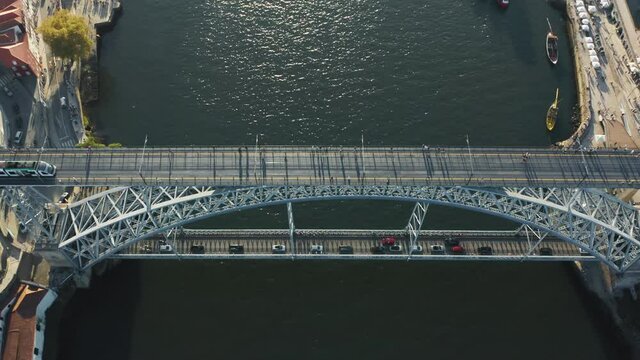 Porto. Portugal. Drone footage of city tram operating at upper deck of Dom Luis I Bridge. Pedestrians, vehicles and public transport use metal decks to cross the river. High quality 4k footage
