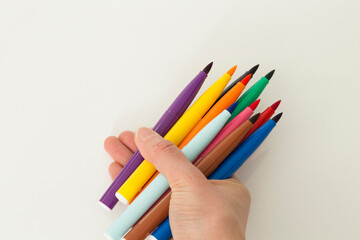 colorful felt-tip pen in the hand on the white background. 