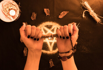 brujería, oráculo o lectura con runas de madera, estrella pentagonal de arena con manos de mujer...