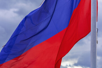 The tricolor state flag of Russia on a cloudy sky background