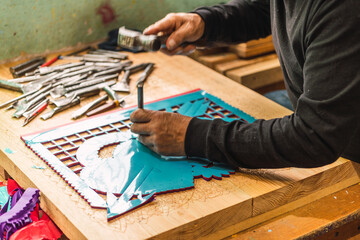 Paper picado worker chiseled on china paper to create figures and then be hung, paper picado is a traditional Mexican craft.