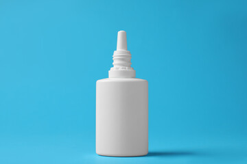 Bottle of nasal spray on light blue background