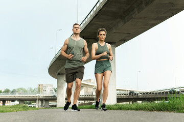 Sportive couple during jogging workout on city street