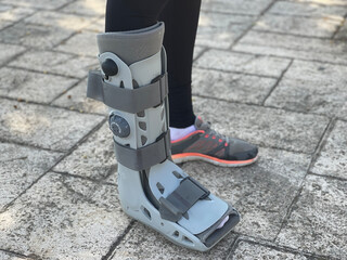 Photograph of orthopedic walking boots women with foot injury, fracture or sprained ankle. Patient...