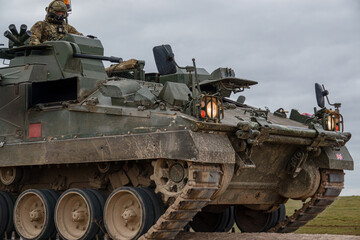 British army Warrior FV512 mechanized recovery vehicle tank in action on military battle exercise,...